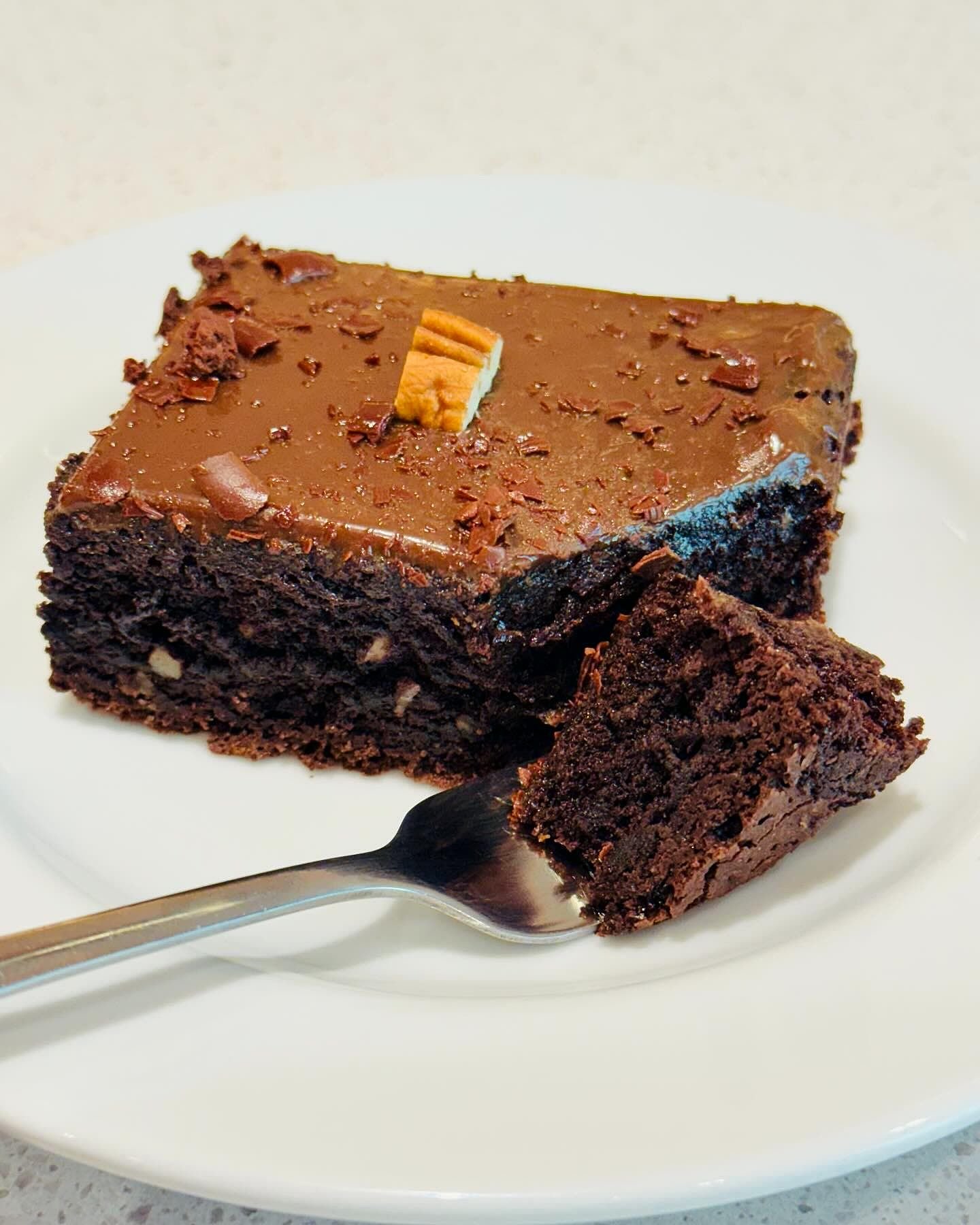 Fatia de brownie com cobertura de chocolate.